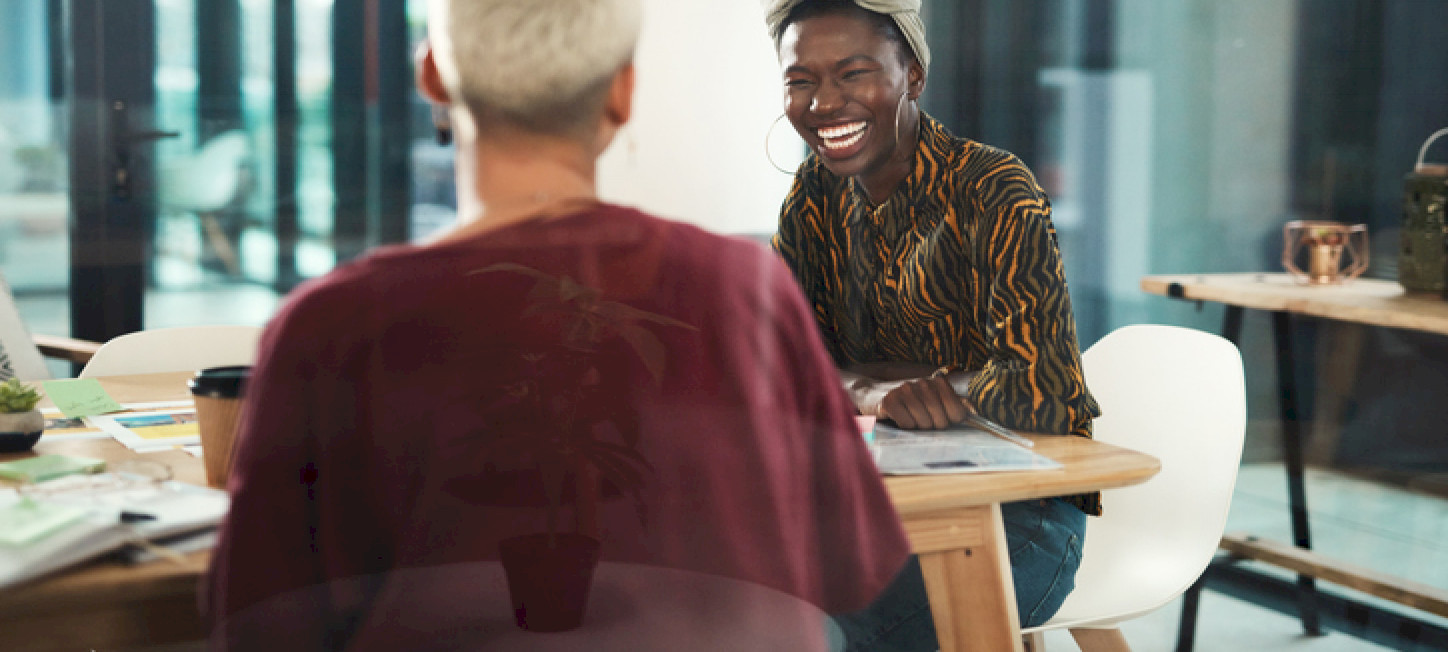 A young businesswoman laughing with a colleague