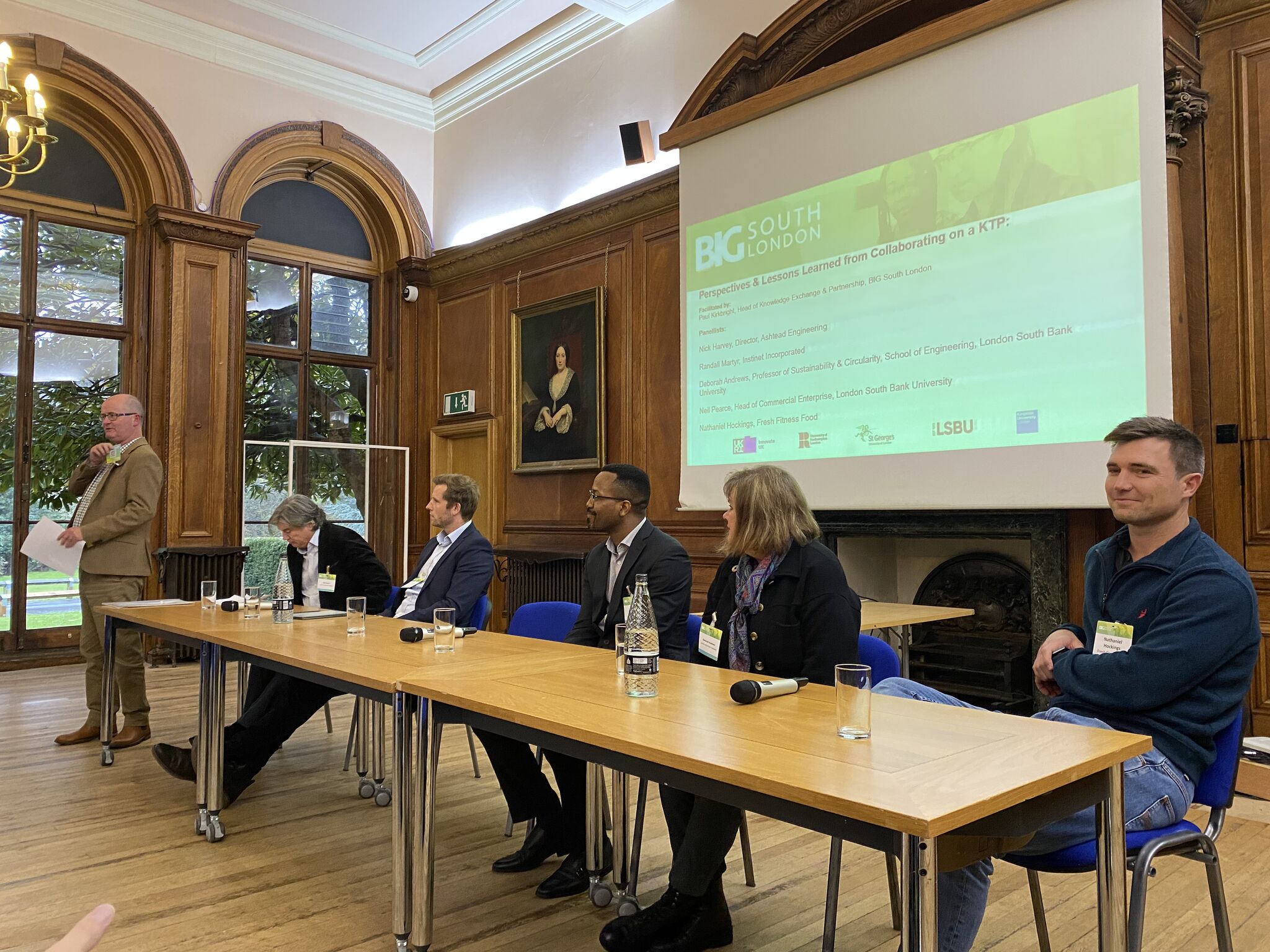 Panel discussion showing panellists and facilitator with microphone.