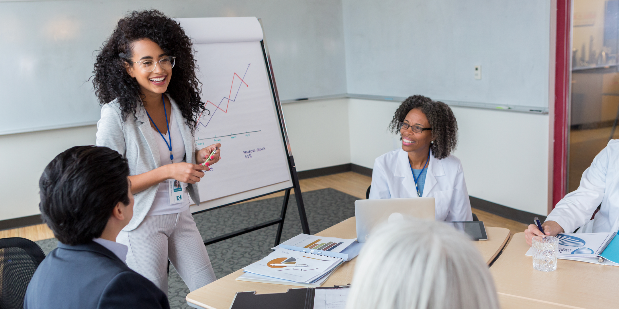 Smiling female hospital administrator facilitates meeting stock photo