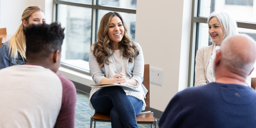 People participate in a therapeutic group discussion, sharing insights and offering emotional support in a safe environment.